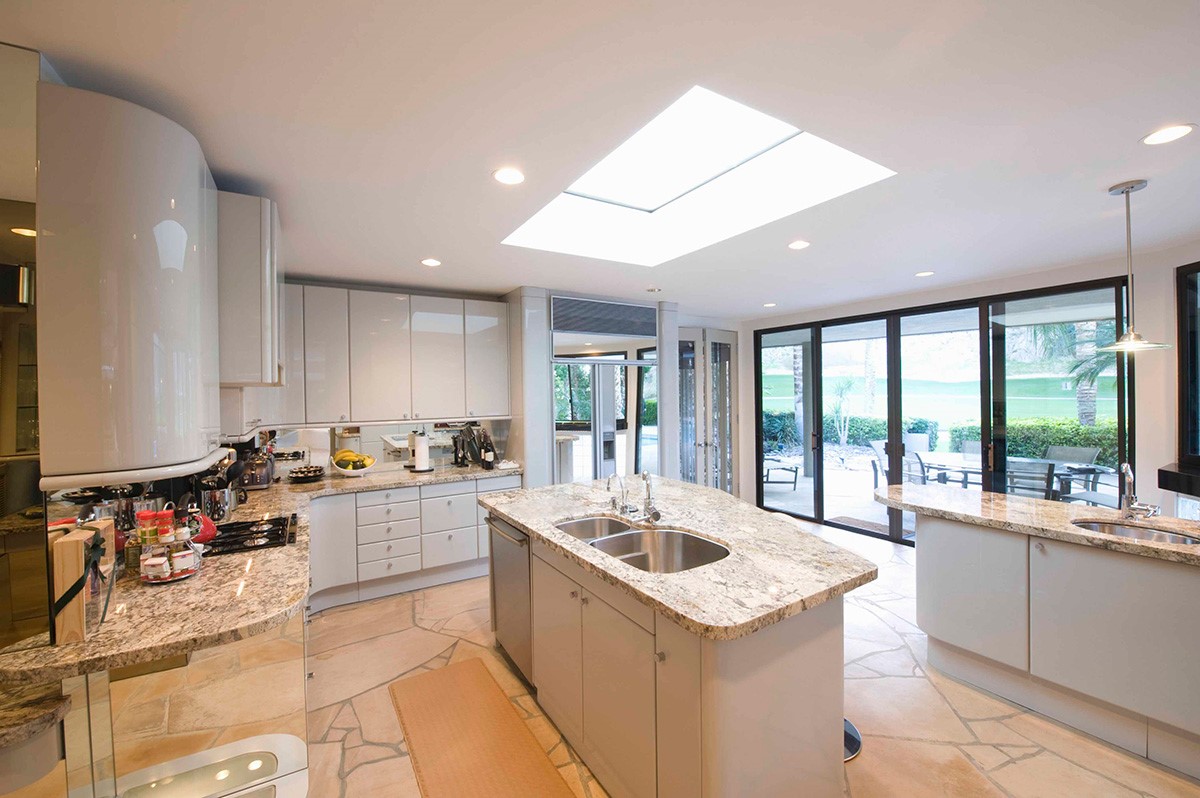 large bright kitchen with skylights and grey marble tops