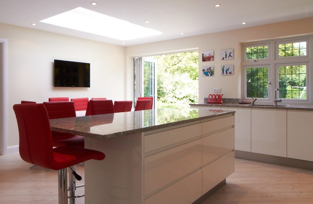 modern open plan kitchen with breakfast bar and red stools